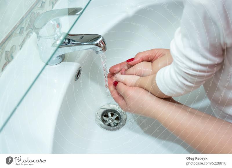 Mom washes baby's hands in the bathroom person child hygiene water clean care soap health girl woman cute lifestyle wet mother beautiful childhood washing white