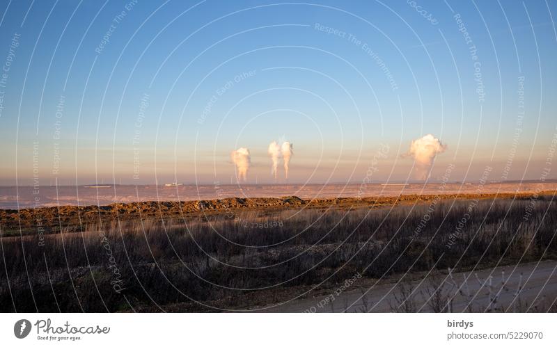 Emissions from coal-fired power plants penetrate the natural cloud layer. Desert landscape at the Hambach opencast lignite mine Soft coal mining CO2 emission