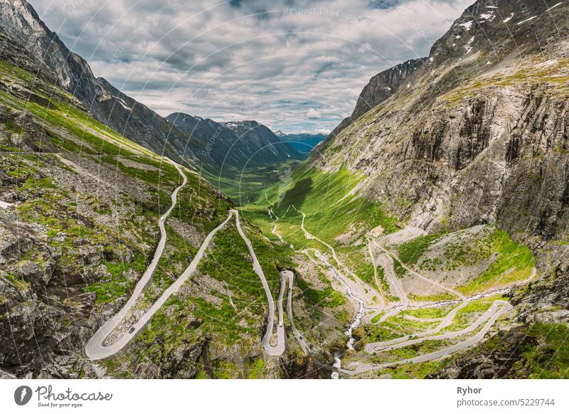 Trollstigen, Andalsnes, Norway. Cars Goes On Serpentine Mountain Road Trollstigen. Famous Norwegian Landmark And Popular Destination. Norwegian County Road 63 In Summer Day