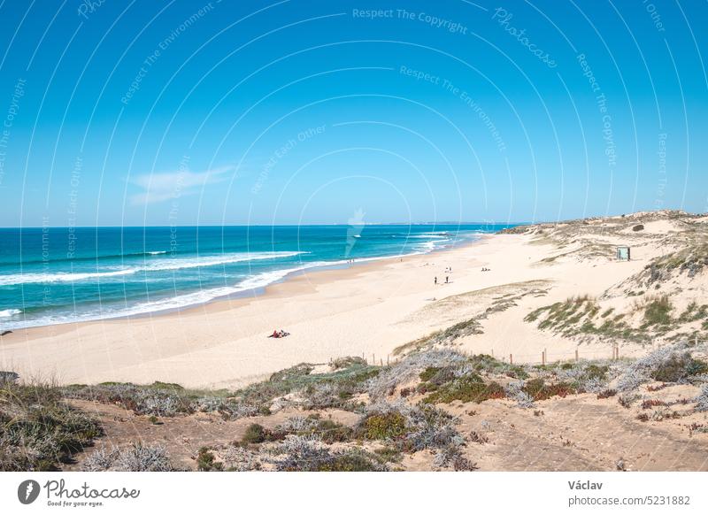 Rocks surround the sandy beach of Praia do Malhao Sul on the Atlantic coast near Vila Nova de Milfontes, Odemira, Portugal. In the footsteps of Rota Vicentina. Fisherman trail