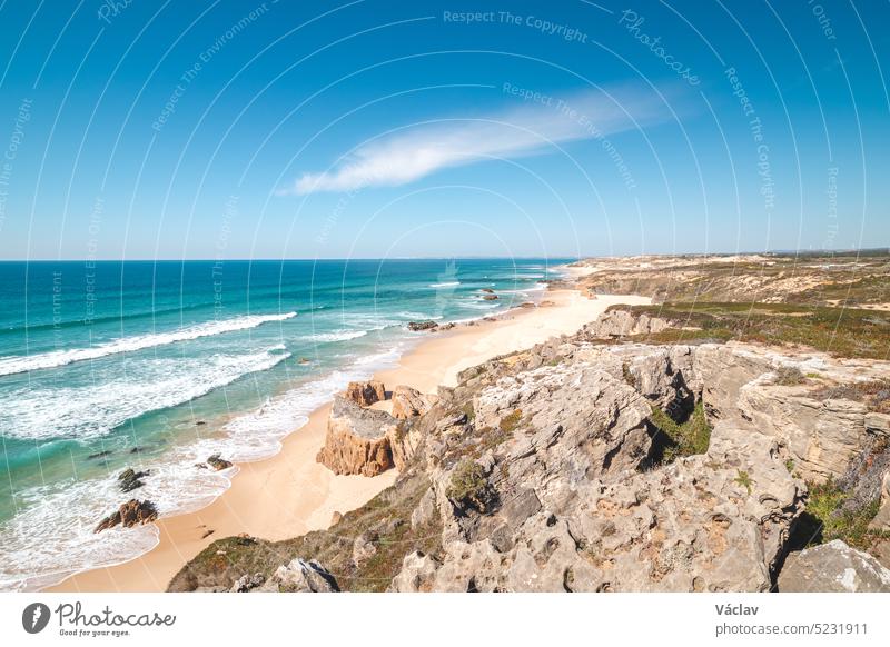 Rocks surround the sandy beach of Praia do Malhao Sul on the Atlantic coast near Vila Nova de Milfontes, Odemira, Portugal. In the footsteps of Rota Vicentina. Fisherman trail