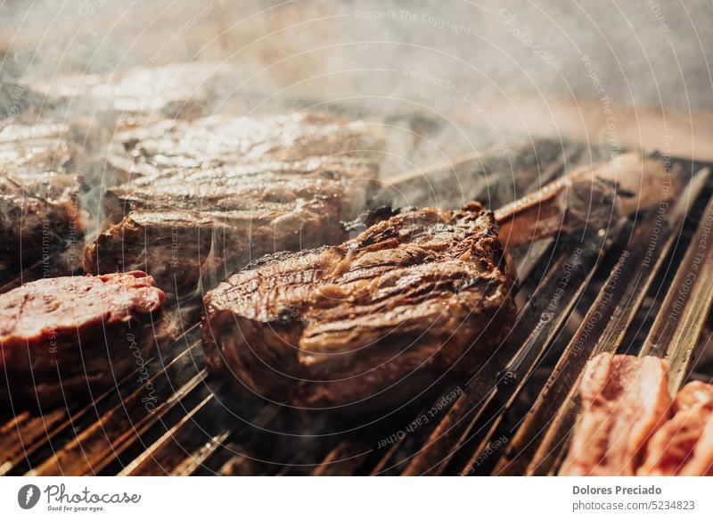 Some excellent pieces of Argentinian beef on a charcoal grill appetizing background barbecue barbeque barbequing bbq bone-in braai closeup cooked cooking