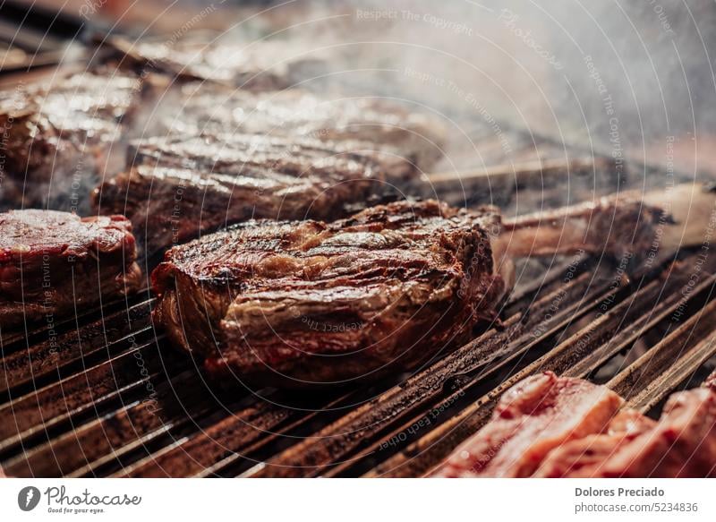 Some excellent pieces of Argentinian beef on a charcoal grill appetizing background barbecue barbeque barbequing bbq bone-in braai closeup cooked cooking