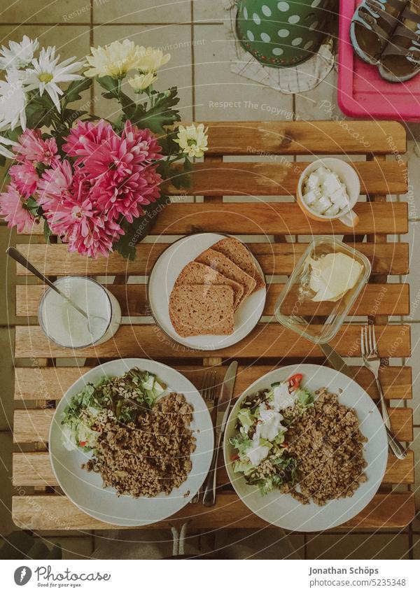 Beautiful set garden table with food and flowers on the balcony, top view minced meat Meat dishes green summer wooden floral home nature decoration design