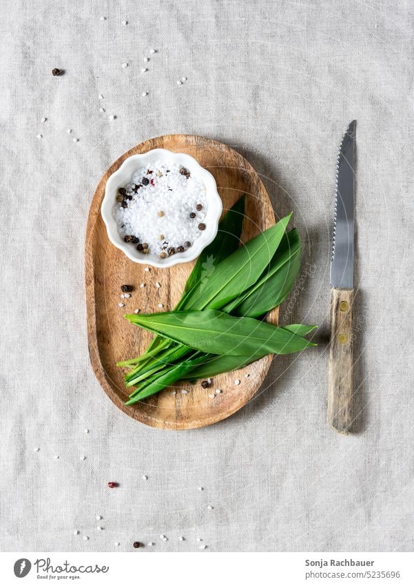 Fresh wild garlic on a cutting board. Club moss Green Spring Leaf Chopping board Food Herbs and spices Vegetable Organic produce Ingredients Salt Pepper bowl