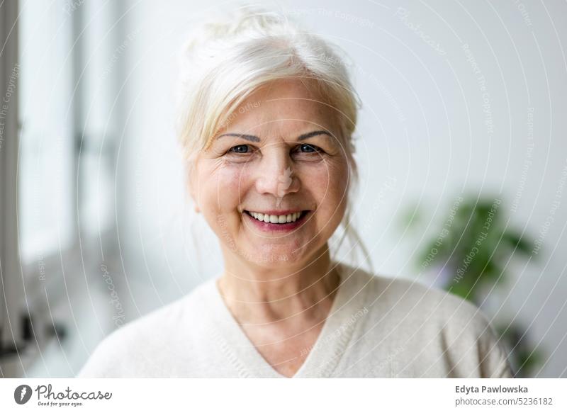 Portrait of smiling senior woman looking at camera real people indoors loft window home mature adult one person attractive successful confident beautiful female