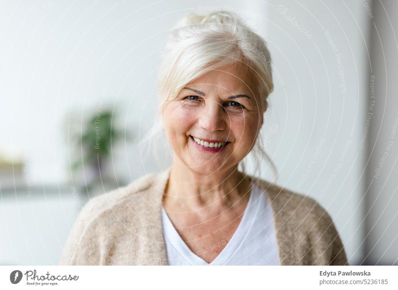 Portrait of smiling senior woman looking at camera real people indoors loft window home mature adult one person attractive successful confident beautiful female