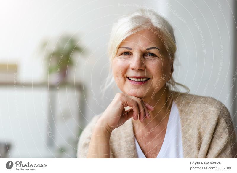 Portrait of smiling senior woman looking at camera real people indoors loft window home mature adult one person attractive successful confident beautiful female