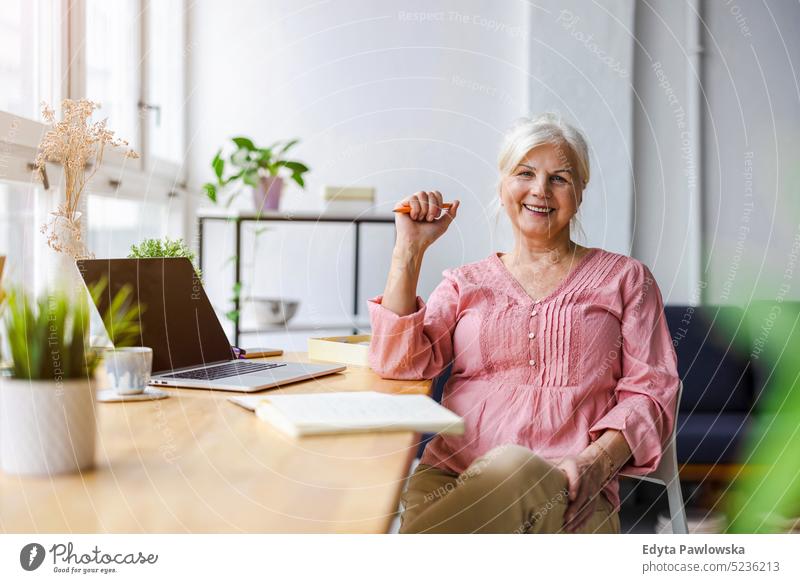 Portrait of smiling mature businesswoman working in an office real people senior indoors loft window home mature adult one person attractive successful