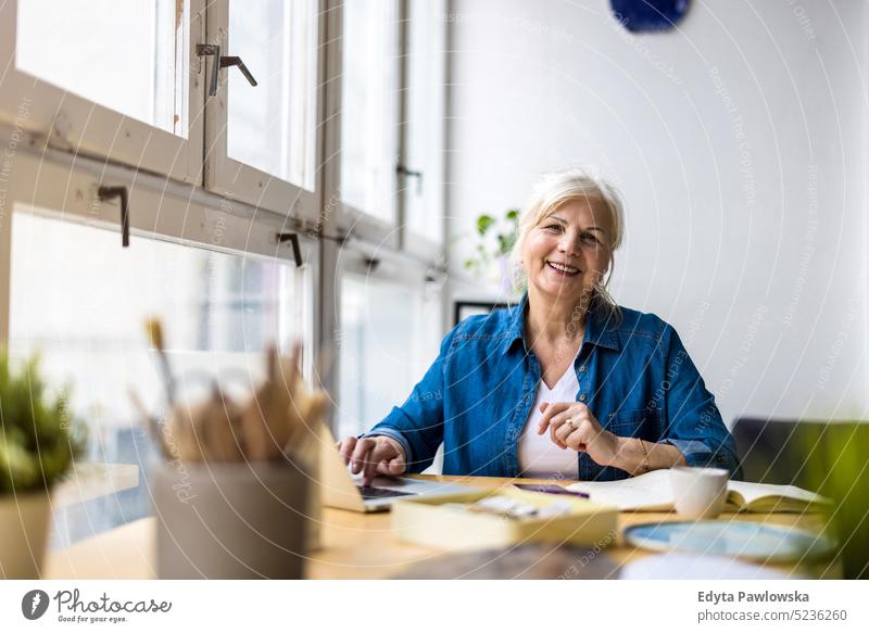 Portrait of smiling mature businesswoman working in an office real people senior indoors loft window home mature adult one person attractive successful