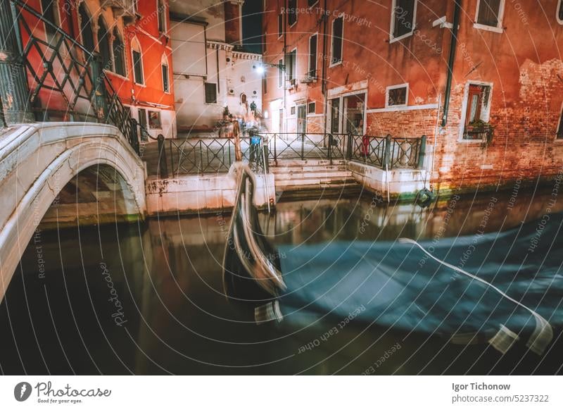 Venice Gondola boat in small channel with arch bridge in lagoon city Venice at night time. long exposure Venezia Italy venice canal view italy street italian