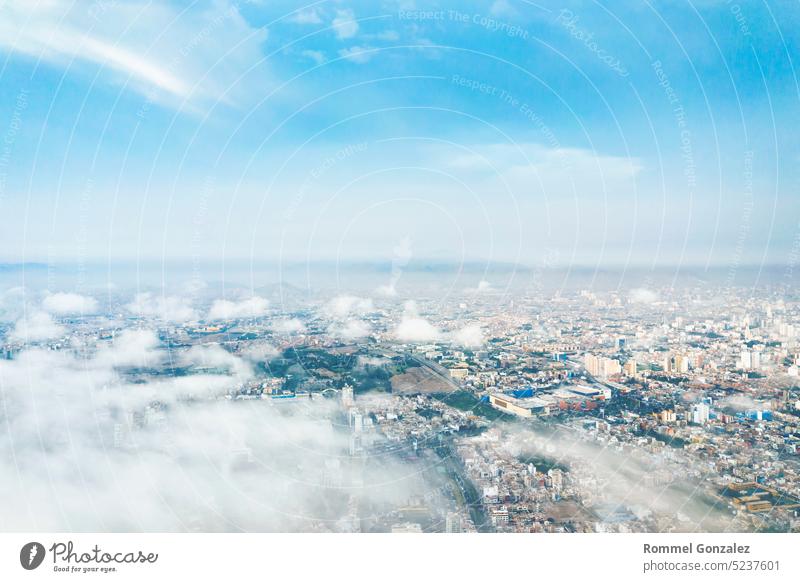 Aerial view of Lima between the clouds, view flying over the tops of the clouds and unveiling the city. capital south america barranco district buildings plane