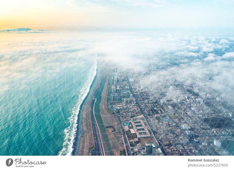 Aerial view of Lima between the clouds, view flying over the tops of the clouds and unveiling the city. capital south america barranco district buildings plane