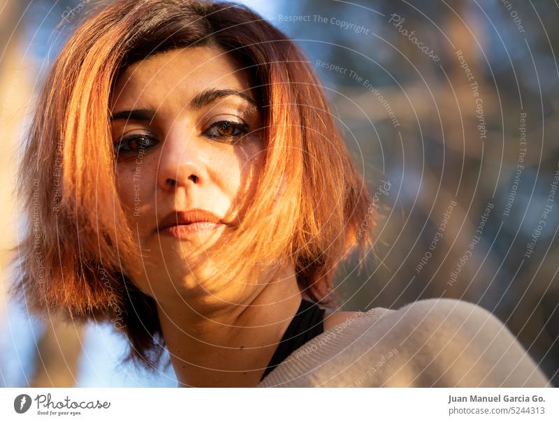 Close-up of a young woman with a piercing gaze, her resilience and confidence shining through in the soft light, embodying natural elegance Confidence