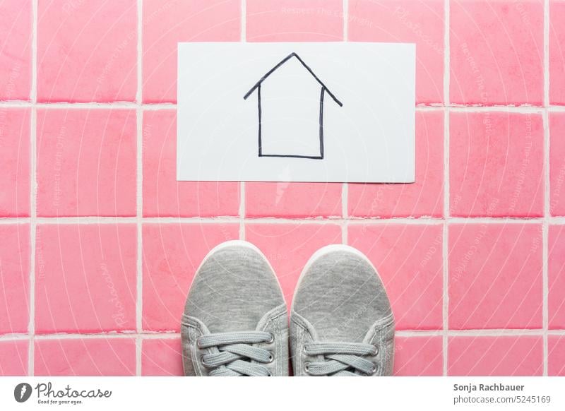 Gray sneakers and an arrow on a notepad. Pink tile floor, top view. Arrow Trend-setting Direction Success pink background tiled floor Future Target Forwards