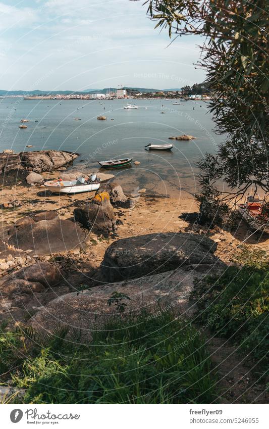 Shore with a beach and fishing boats coast dock copy space landscape galicia tranquil spain nobody shore water vacation travel sand wave sea summer ocean