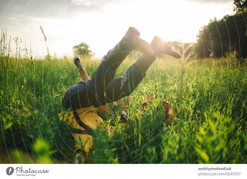 people lie in the field. happy couple lying on the grass feet up. adult barefoot boots boyfriend carefree caucasian copy day family freedom fun girl girlfriend