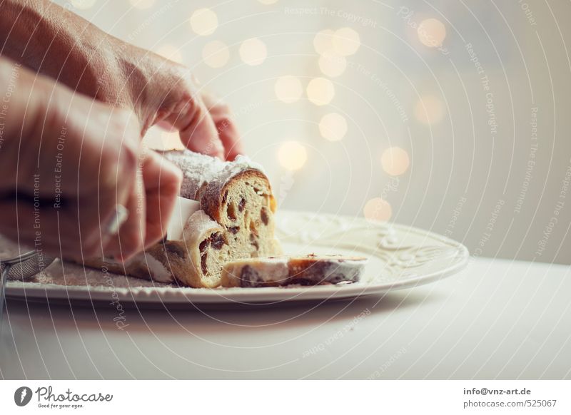 tunnel Food Dough Baked goods Cake Dessert Stollen Gold Christmas & Advent Knives cut Raisins Hand To hold on Colour photo Interior shot Studio shot