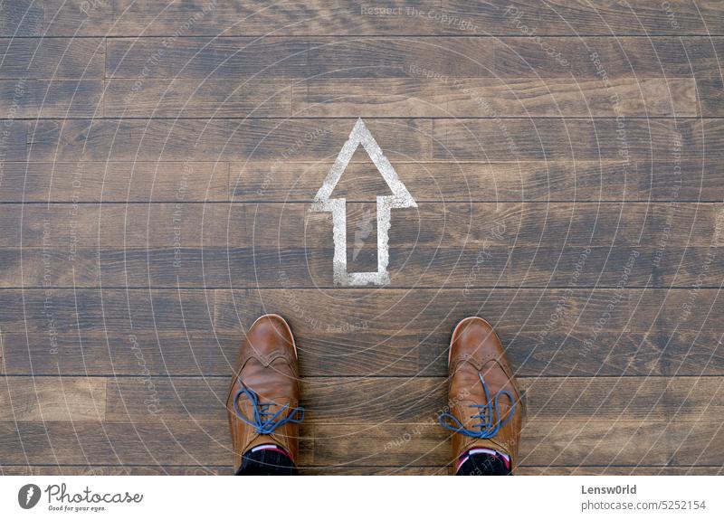 The way forward - Man standing in front of arrow sign on wooden floor background black business career career development concept decision direction future