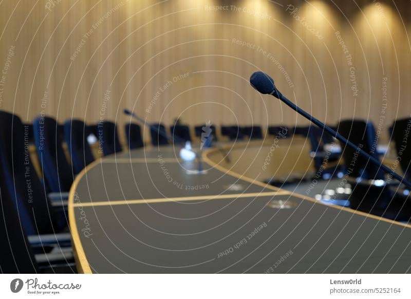 Conference room with wooden walls and microphones at each seat board room business closeup communication conference convention center debate desk discussion