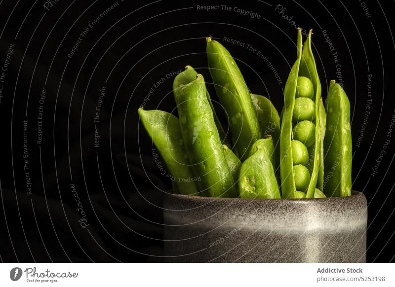 Pot with pea pods in studio pot ripe harvest vegetarian food pile bunch heap organic fresh whole natural bean agriculture product vegan nutrient stack nourish