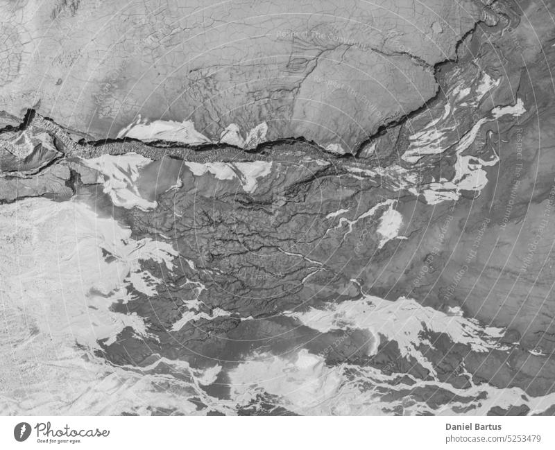 The structure of cracked wet earth at the bottom of the lake, creating irregular patterns, structure, background. Amazing shapes created by nature at the bottom of a lake where there is no water