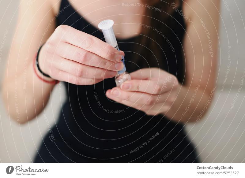 Woman filling up the reservoir of her insulin pump with insulin Filling up Reservoir Insulin pump Type 1 diabetes Diabetes care Medical equipment