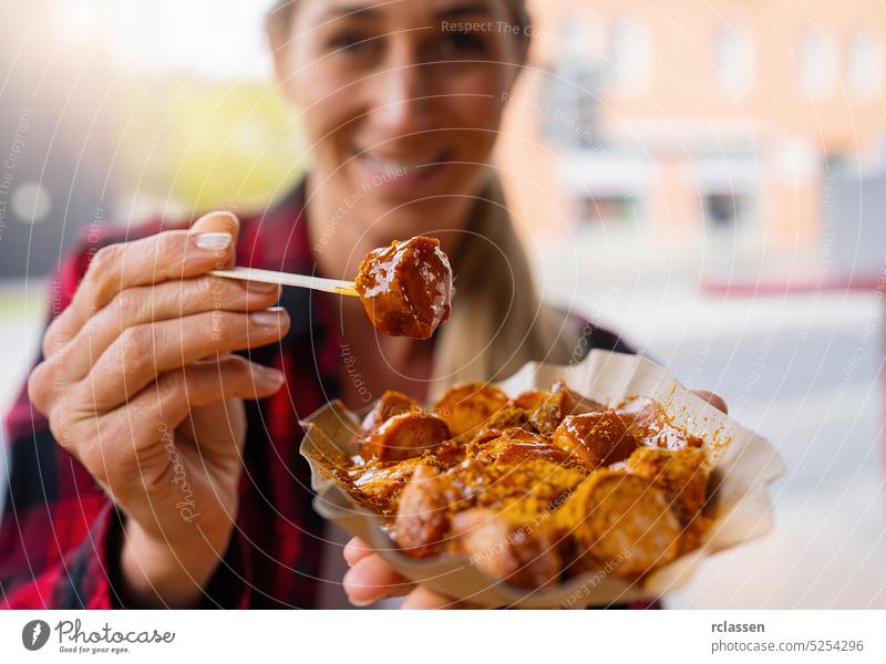 Woman eating Currywurst fast food German sausage in outdoor street food cafe berlin currywurst junk food hotdog bratwurst calories caucasian city diet fat fried