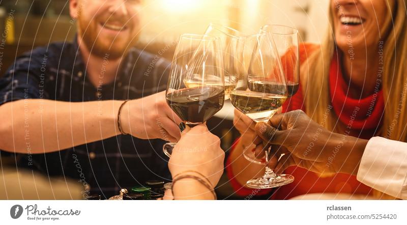 Happy friends clinking glasses for smiling and toasting wine in Italian cocktail bar restaurant - Young and old people enjoying appetizer before dinner, Focus on wineglasses, banner size