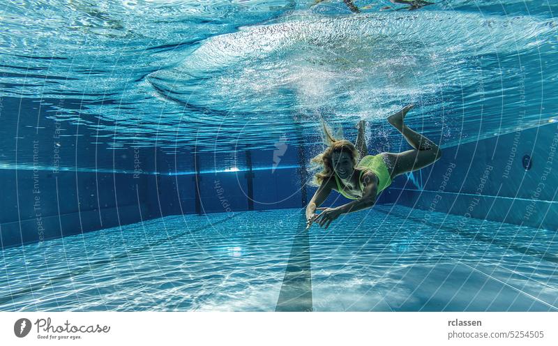 Underwater woman portrait in swimming pool thermal resort splash smiling underwater fashion beautiful young girl hair dive happy holiday people summer nature