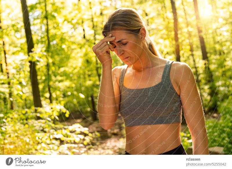 woman having headache during training at public park, rubbing her head accident aching activity athlete athletic body training bodybuilder cardio care diet