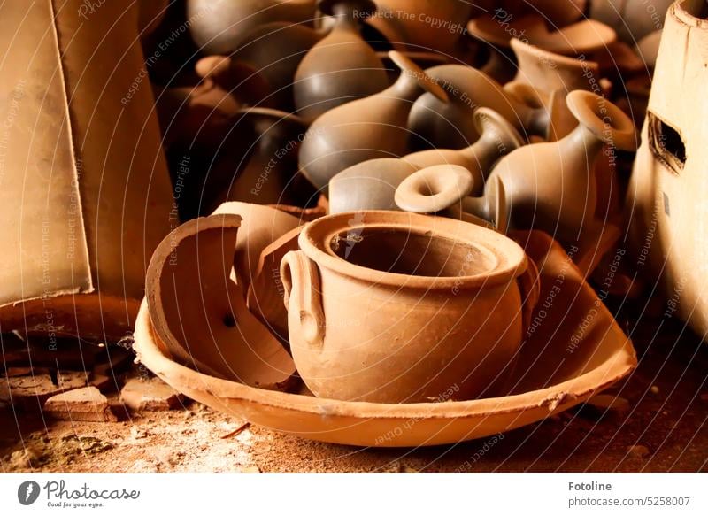 Vases, a bowl, a pot, shards and old cardboard boxes lie on the floor of a long-abandoned pottery. Pot shell Pottery Tone Brown Craft (trade) Art Workshop