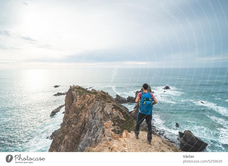 Backpacker rests during his journey along the Atlantic coast in western Portugal, along the famous Fisherman Trail. Resting at sunset backpacker tourist odemira