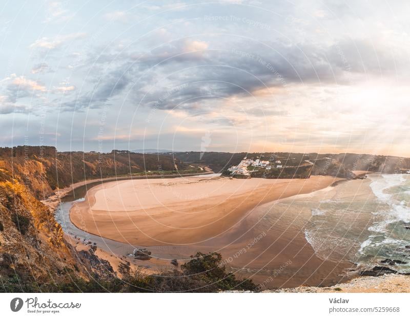 Odeceixe beach under the sun at sunset. The beauty of the Algarve region on the Atlantic coast of western Portugal. In the footsteps of the Fisherman trail. A dream tourist destination