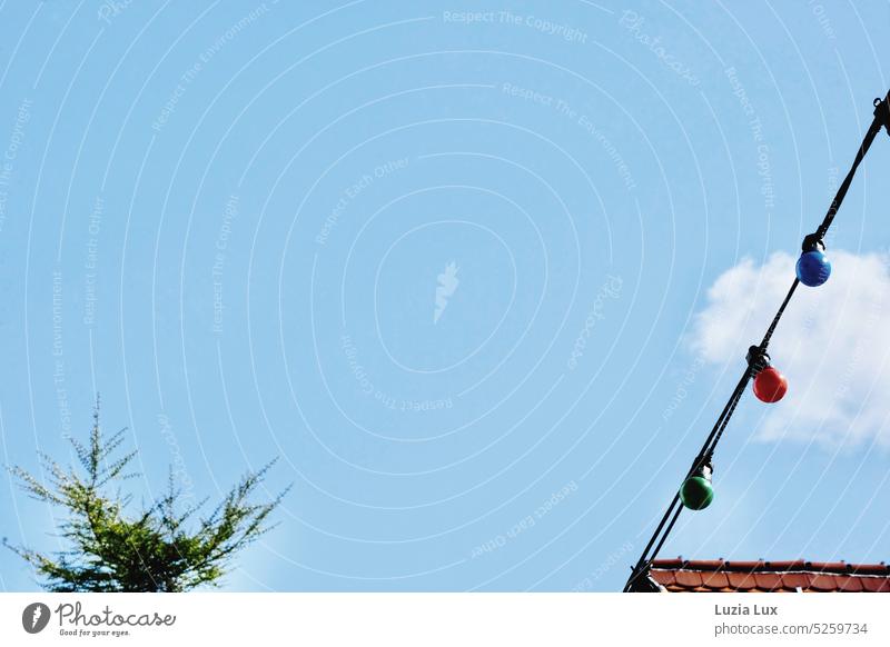 View of the sky: to be seen are red roof tiles, a string of bulb lights green, red, blue and a steep, forgotten Christmas tree Sky Sky blue Blue Clouds