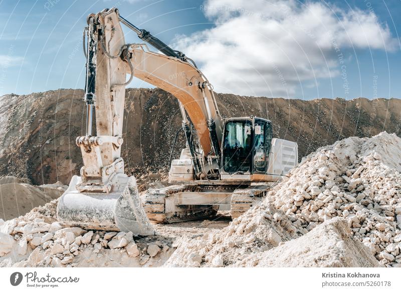 Caterpillar excavator with large bucket on construction site or quarry. Mining heavy machinery details. Earthmoving, excavations, digging on soils. industry