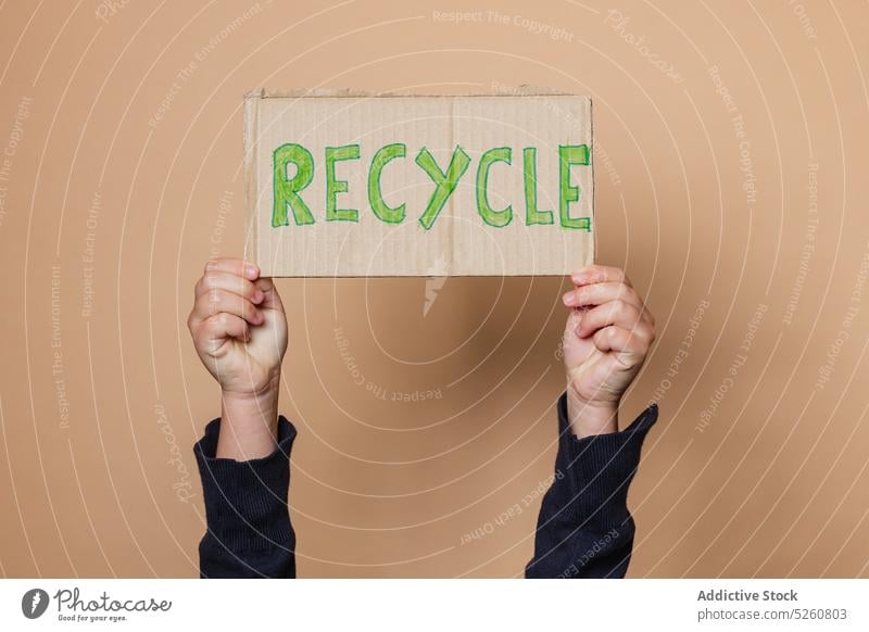 Crop child showing Recycle poster recycle environment inscription carton protest activist save kid arms raised placard banner demonstrate ecology cardboard