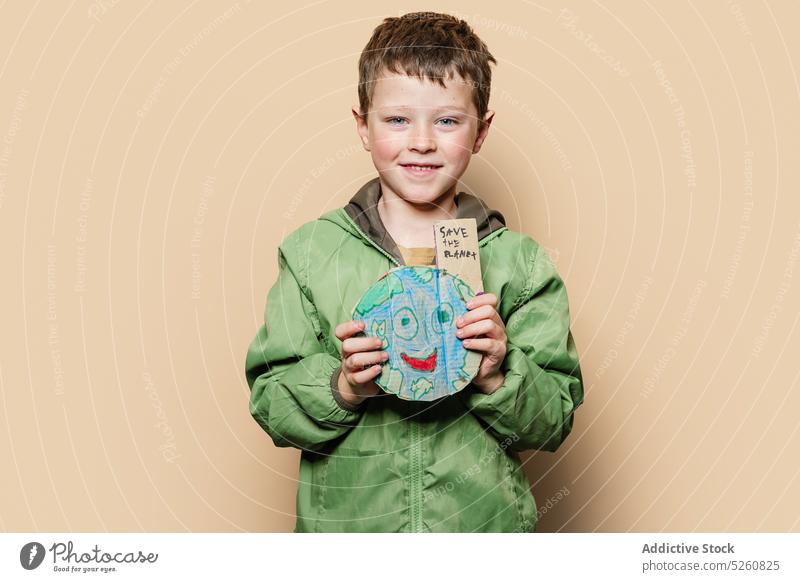 Boy with handmade Earth during environmental campaign boy earth protest save planet inscription ecology show kid activist pollute demonstrate response cardboard