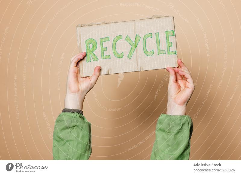 Crop child showing Recycle poster recycle environment inscription carton protest activist save kid arms raised placard banner demonstrate ecology cardboard