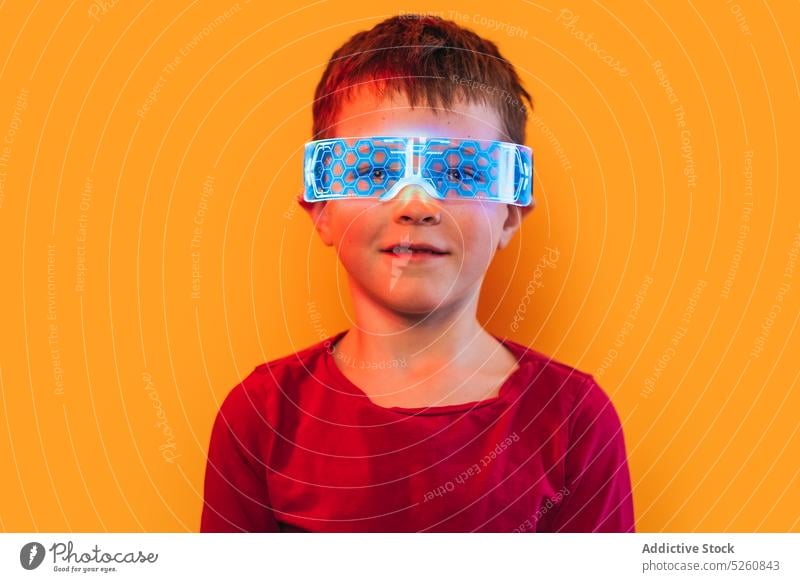 Boy in glowing futuristic goggles boy glasses neon illuminate ornament portrait colorful bright smile style kid vivid child t shirt shiny cyberpunk cute