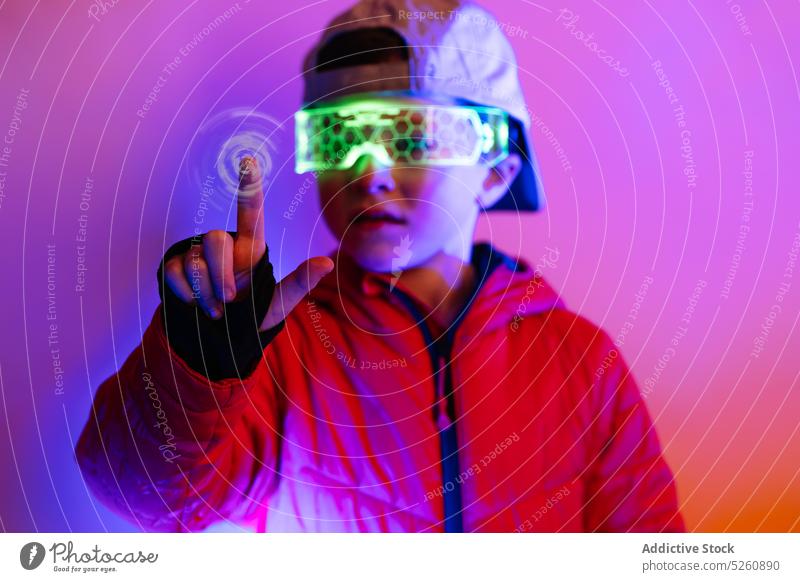 Futuristic boy interacting with digital interface futuristic cyberspace control press neon illuminate bright style glasses goggles modern virtual reality vr