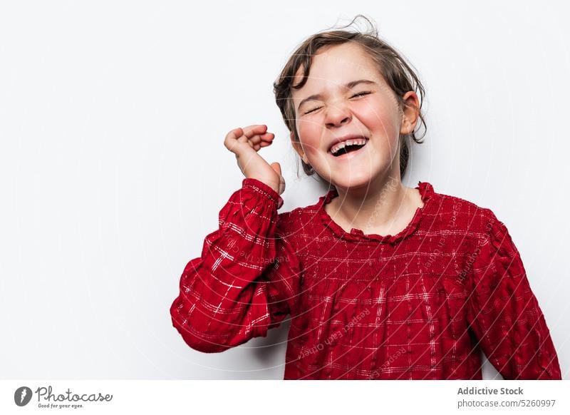 Happy girl laughing at joke happy touch hair humor funny child bright cute positive glad cheerful eyes closed optimist kid content adorable vivid carefree