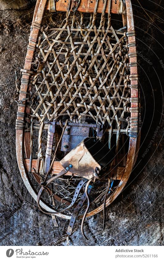 Antique snowshoes hanging on stony wall antique ancient detail wicker culture metal wooden design various ornament vintage classic daytime rough old material