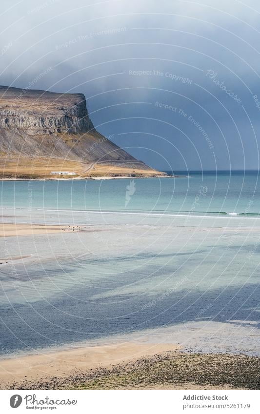 Picturesque seascape under thick clouds mountain coast wave rocky shore breathtaking nature landscape beach seashore scenery sky ocean iceland water cloudy