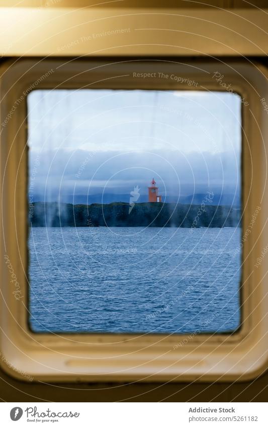 View from window of lighthouse sea ripple rain lonely water weather shore nature coast ocean sky iceland landscape gloomy scenic beacon dull marine nautical