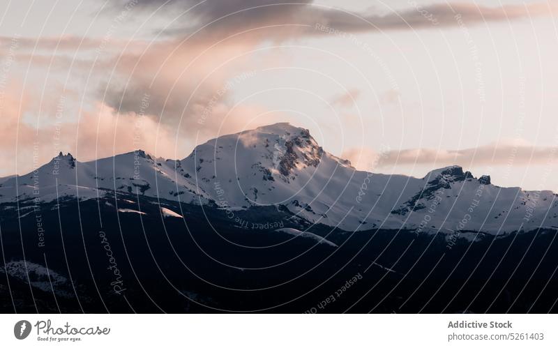 Mountain ridge under cloudy sunset sky mountain formation breathtaking nature snow gloomy sundown landscape sunrise massive highland rough dusk environment peak