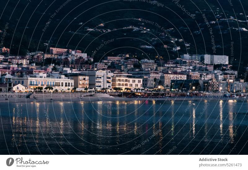 Illuminated city on seashore at night illuminate dark building embankment water architecture sicily italy waterfront exterior house coast glow construction