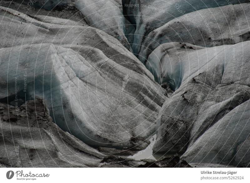 Melting glacial ice covered with volcanic ash Glacier ice Glacier tongue Glacial melt Gray White light blue Blue Ice formations Cold Frost Iceland Climate