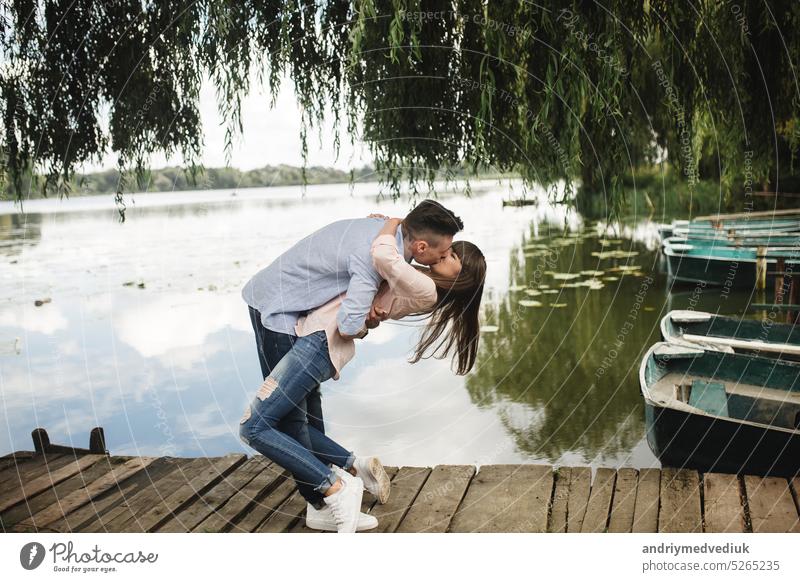 Cute couple walking near water. Girl in a white shirt. Pair by the river. Loving young couple near the river with boats. love without borders. selective focus