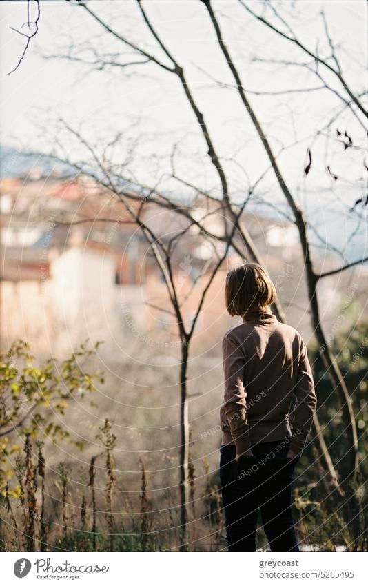 Boy on the Hill in the Forest vertical boy teenager youth sweater hill forest nature outdoor small town looking distance peaceful contemplation serenity